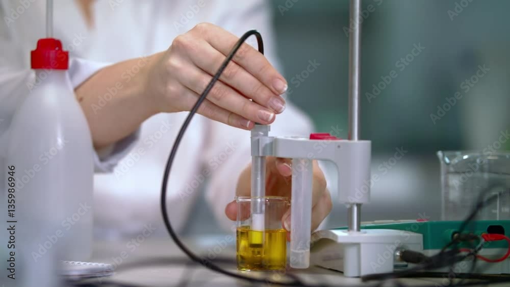 Chemical potentiometer measure acidity of liquid in lab. Lab woman