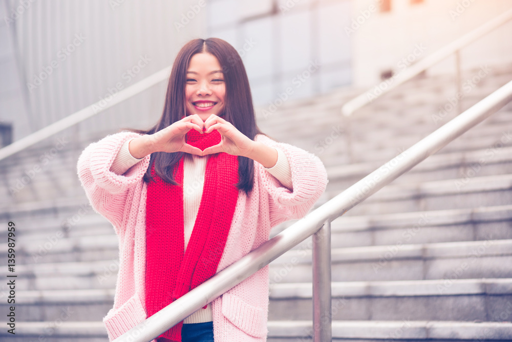 Valentines day concept of  young woman making heart shape with hands.
