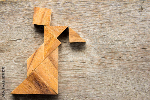 Wooden tangram puzzle in woman held the lantern shape background