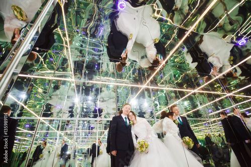 Obraz na plátně Bride and groom in mirrored room, mirror labyrinth