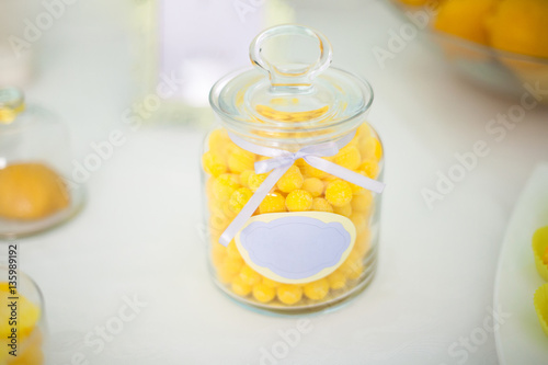 Yellow candy in a glass jar on sweet table