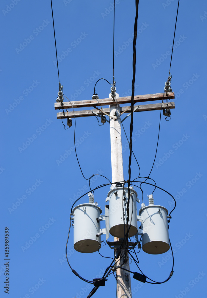 Three transformers on a power pole with wires Three transformers on a power pole with wires