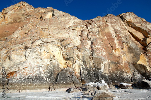 Rocky headland on Rocky shore of lake Baikal in winter the Western coast of lake Baikal sticks in the ice-covered pond 