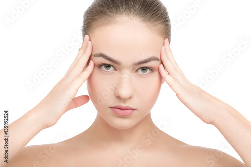 Beautiful young woman with headache touching her temples, isolated in white