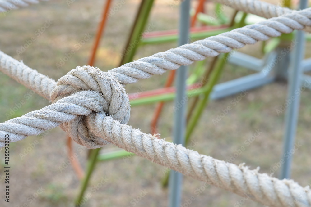 Rope knot line tied together with playground background,as a symbol for trust, teamwork, coordination or collaboration. Rope knot line tied together with playground background,as a symbol for trust, teamwork, coordination or collaboration.