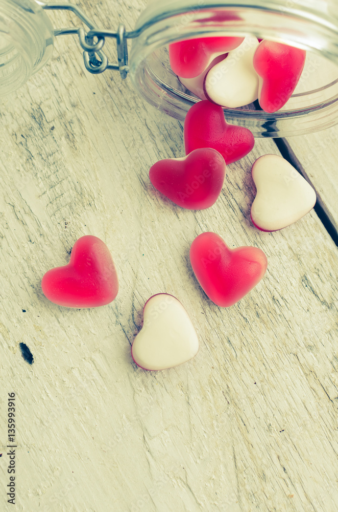 Obraz premium Red heart shape candy in a glass jar