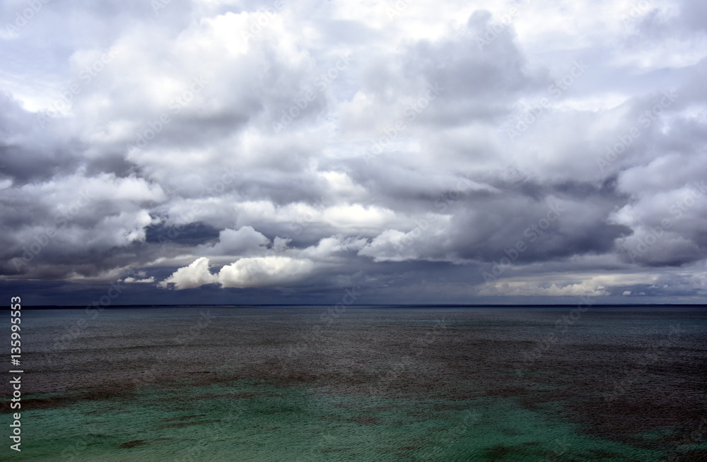 Gushing sea on a cloudy day. Horizontal view of dramatic overcast sky and sea. Fifty shades of blue.