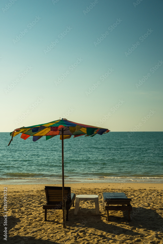 Beach chairs on the white sand beach with cloudy blue sky