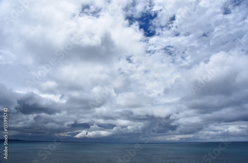 Gushing sea on a cloudy day. Horizontal view of dramatic overcast sky and sea. Fifty shades of blue.