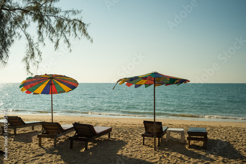 Beach chairs on the white sand beach with cloudy blue sky