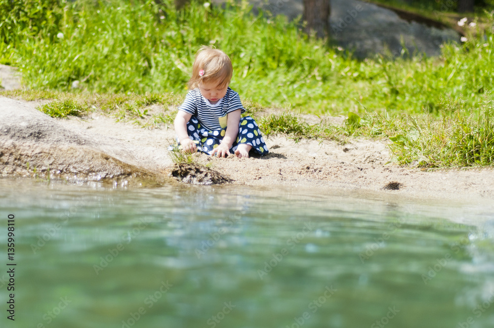 Little girl playing on the river bank Little girl playing on the river bank