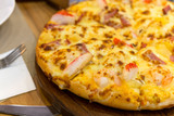 Crab stick and pepperoni Ham pizza on the wooden table.