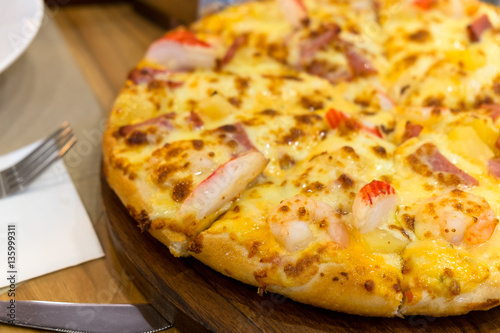 Crab stick and pepperoni Ham pizza on the wooden table.