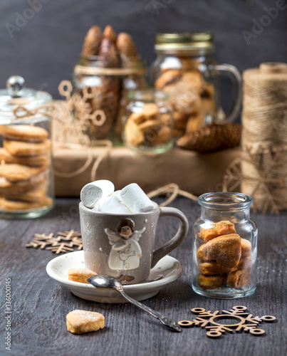 Cup of cocoa on a gray background. Cookies in glass jars