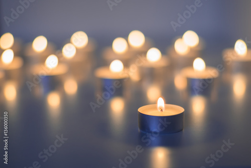 Flame of many candles burning on the background blue color