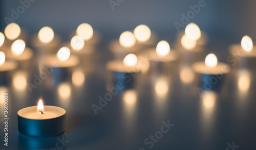 Flame of many candles burning on the background blue color