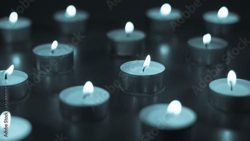 Flame of many candles burning on the background blue color