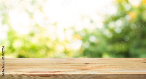 Empty wood table top on blur abstract green from garden in morning