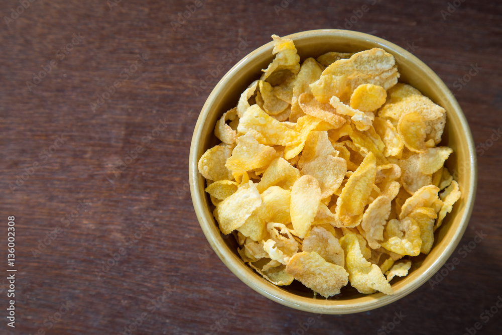 Bowl of corn flakes on wooden table. Bowl of corn flakes on wooden table.