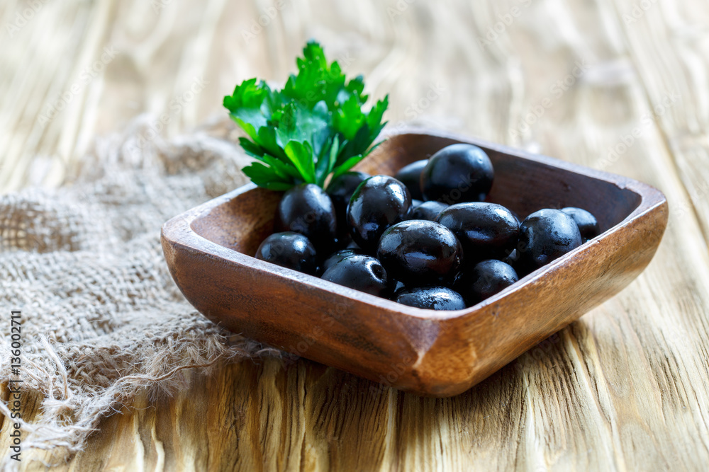 Black olives in a wooden bowl. Black olives in a wooden bowl.