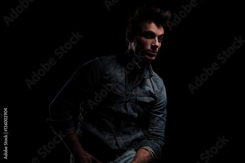 young sexy man in denim clothes looks away
