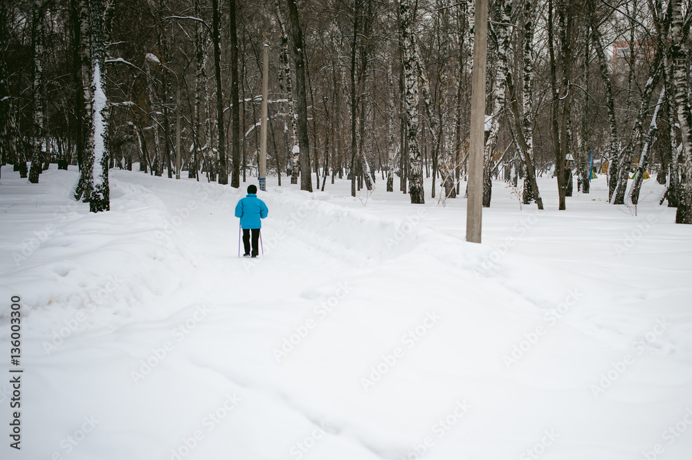 elderly woman is engaged in Nordic walking outdoors in winter