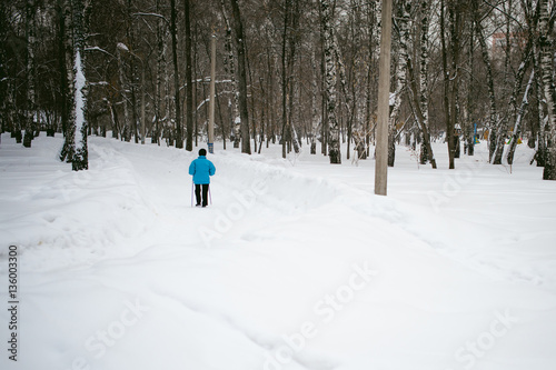 elderly woman is engaged in Nordic walking outdoors in winter