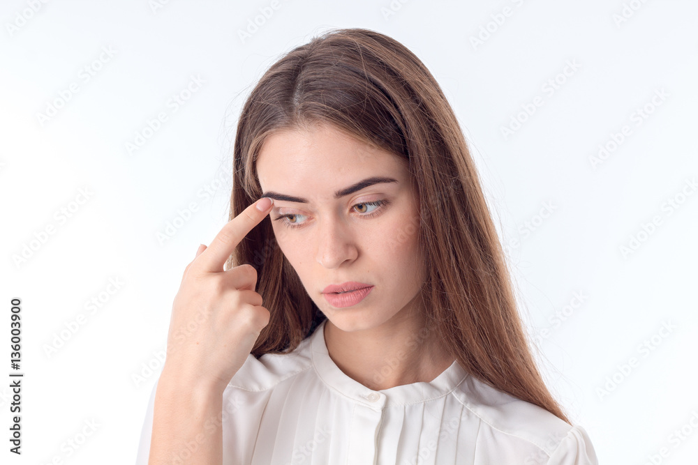 young girl looks away and keeps the finger near the eye young girl looks away and keeps the finger near the eye