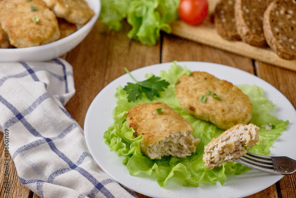 Chicken cutlets with vegetables on a wooden background