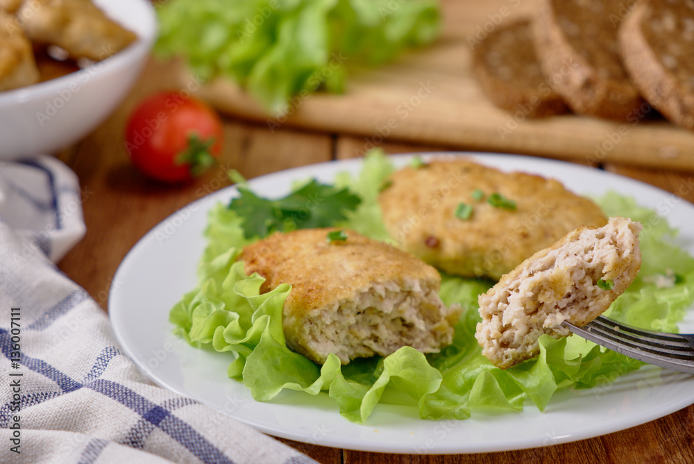 Chicken cutlets with vegetables on a wooden background Chicken cutlets with vegetables on a wooden background