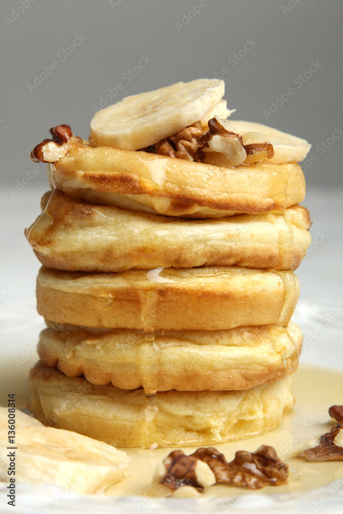 Stack of pancakes with bananas and nuts in the plate. Stack of pancakes with bananas and nuts in the plate.