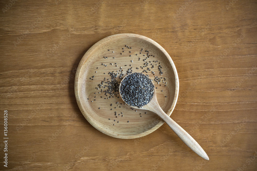 Top View of Chia Seeds with Wooden Plate and Spoon on Wood Table Top View of Chia Seeds with Wooden Plate and Spoon on Wood Table