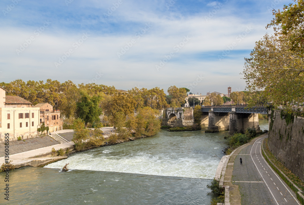 Rome. Italy. Scenic view from the Pons Cestius: a dam on the river Tiber, the left - Isola Tiberina, the ruins of the ancient Emilio bridge and the current Ponte Palatino Rome. Italy. Scenic view from the Pons Cestius: a dam on the river Tiber, the left - Isola Tiberina, the ruins of the ancient Emilio bridge and the current Ponte Palatino