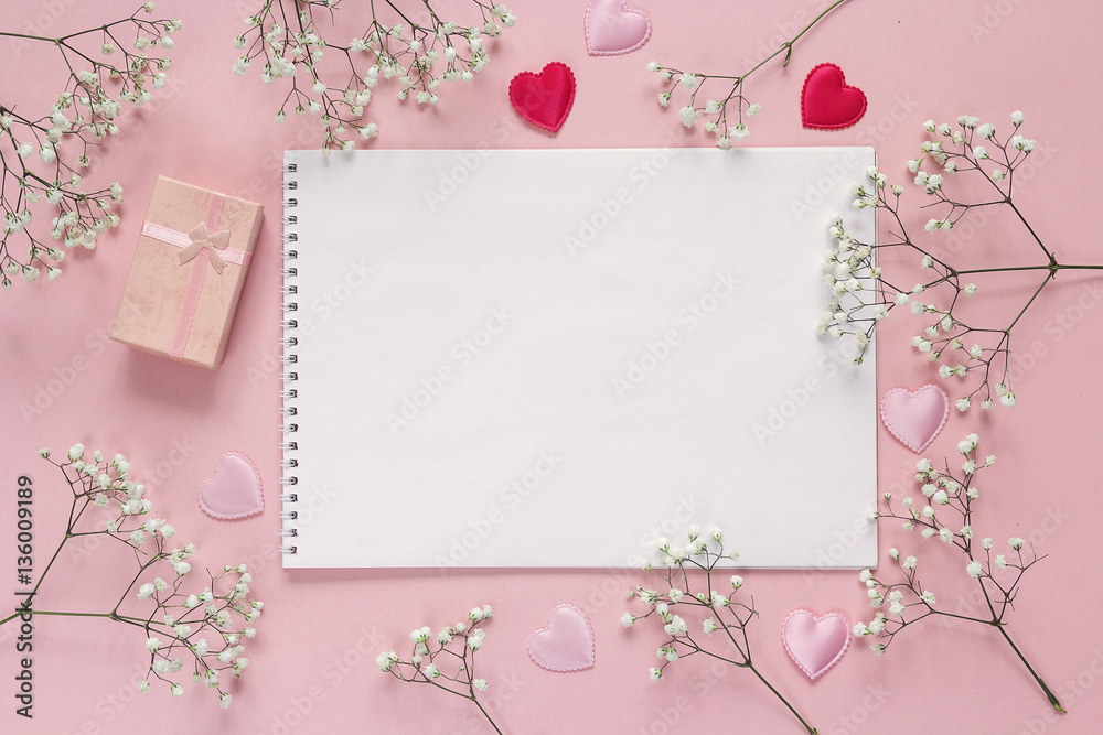 Art album, white flowers and gift box on pink background. Copy s