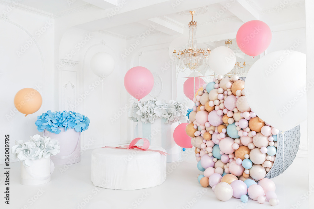 Boxes with flowers and a large pudrinitsa with balls and balloons in room decorated for birthday party. Boxes with flowers and a large pudrinitsa with balls and balloons in room decorated for birthday party.