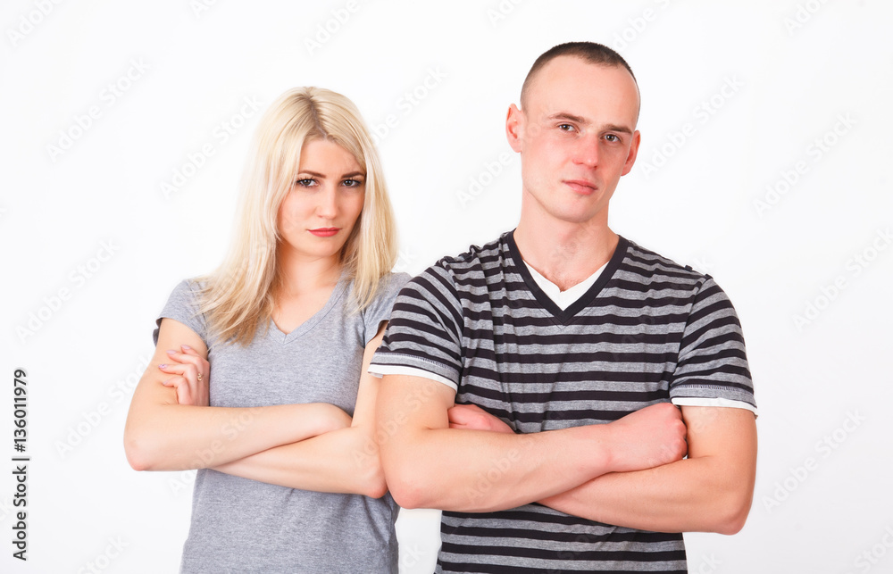 Offended couple standing with crossed arms in studio. Offended couple standing with crossed arms in studio.