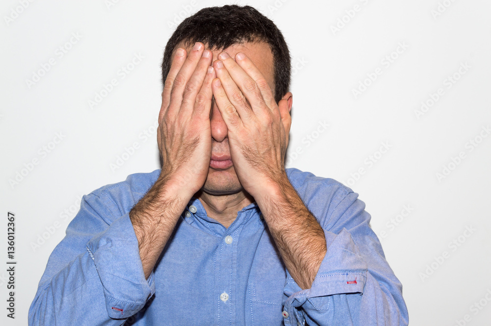 Man covering his eyes with his hands Man covering his eyes with his hands