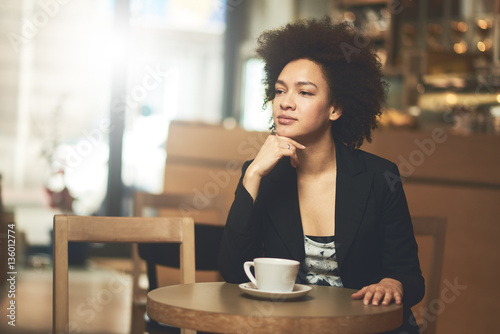 Mixed race, African American woman drinking coffee in cafe