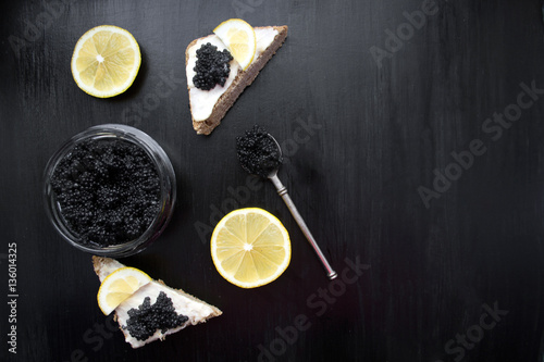 black caviar and canapes on a black background