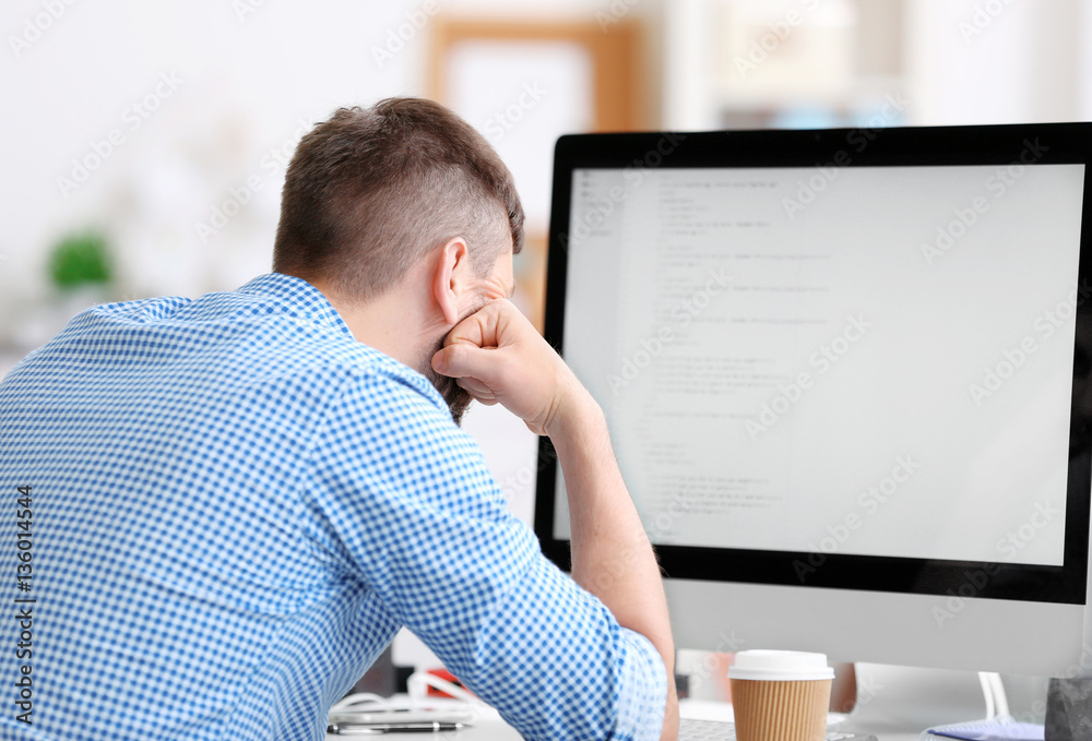 Handsome young programmer working in office