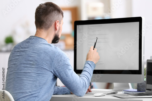 Handsome young programmer working in office photo