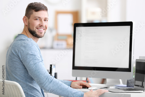 Handsome young programmer working in office