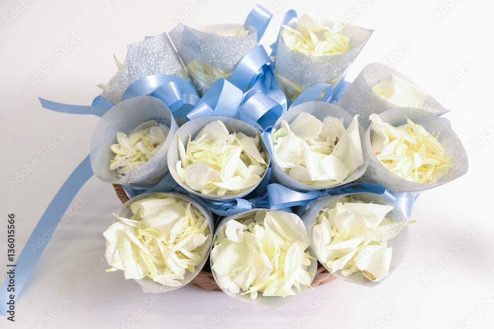 A flower and feather confetti with blue, white rose petals insid