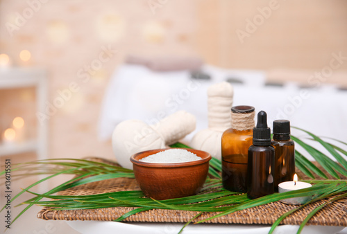 Massage setting with natural oil and herbal compress balls on wicker mat