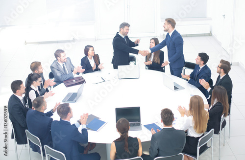 leaders of the two business teams shake hands at a business meet