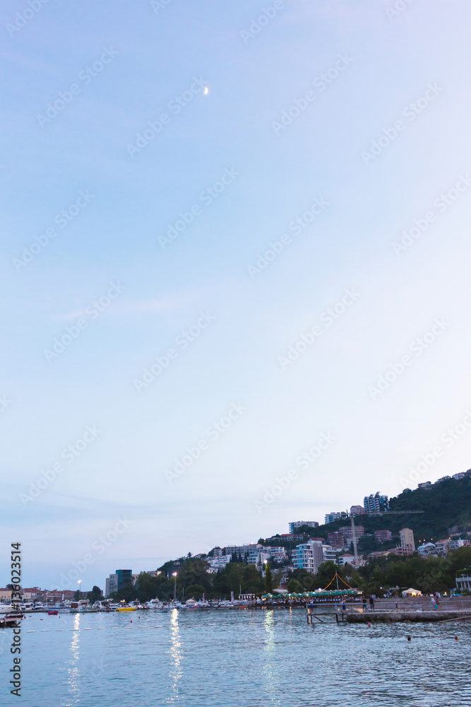 Fototapeta premium Budva the old town cloudy sky over ships and clean sea at sunset, mountain island, montenegro, europe