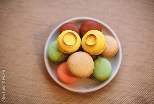 Two wedding rings on the colorful macaroons
