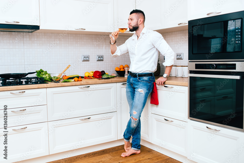 handsome man cooking and drinking a glass of wine. handsome man cooking and drinking a glass of wine.