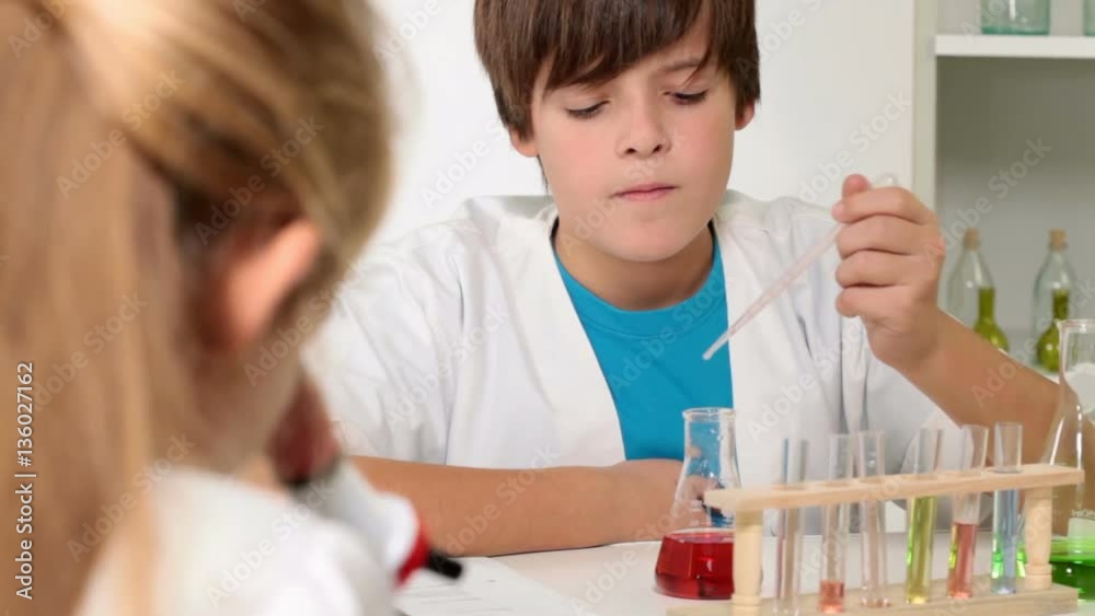 Elementary school chemistry class - kids experimenting, focus on background boy Elementary school chemistry class - kids experimenting, focus on background boy