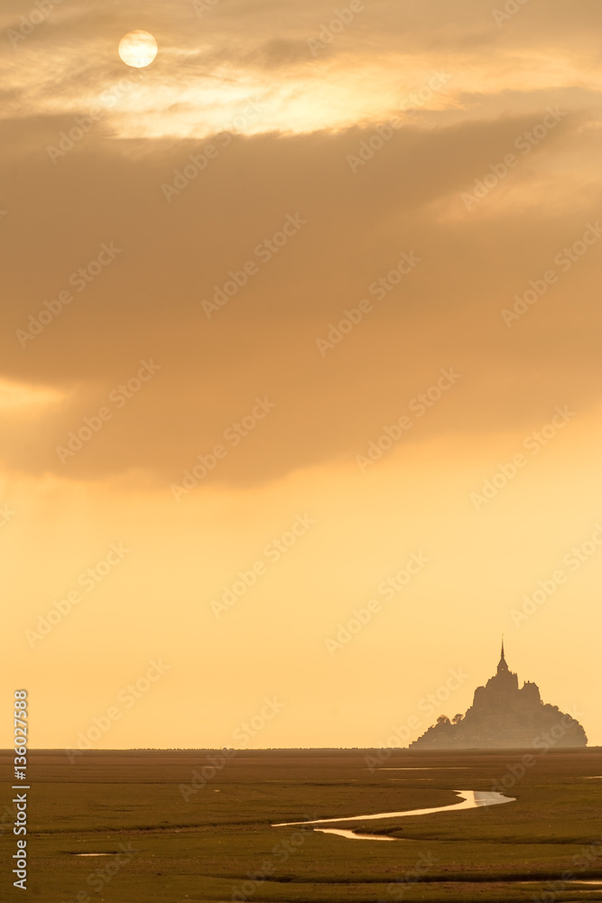 Silhouette of famous Mont Saint Michel on Normandy coast at sunset, France
